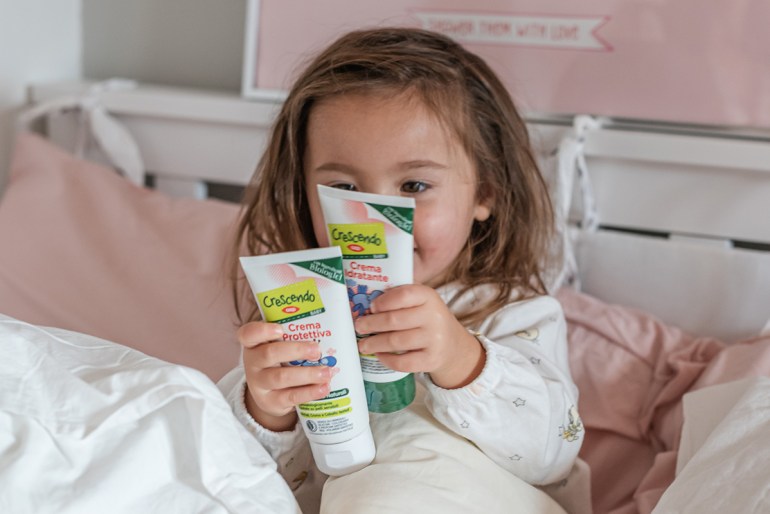 Beatrice con due creme della linea detergenza Crescendo Baby di COOP